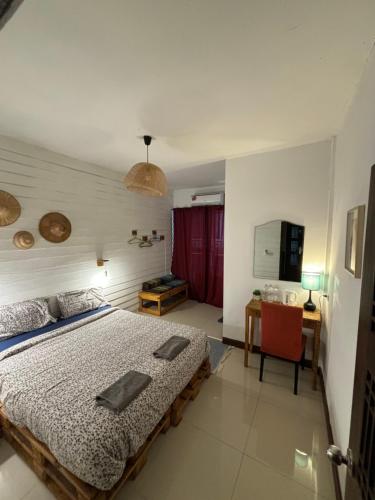 a bedroom with a bed and a table and a chair at La Locanda in Bangkok