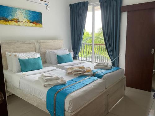 a bedroom with two beds with towels on them at Beach Bliss in Trincomalee