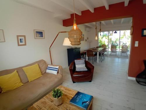 un salon avec un canapé et une table dans l'établissement Maison moderne à 200m de la plage avec jardin et terrasse, 3 chambres pour 6 personnes - FR-1-239-1049, à Labenne