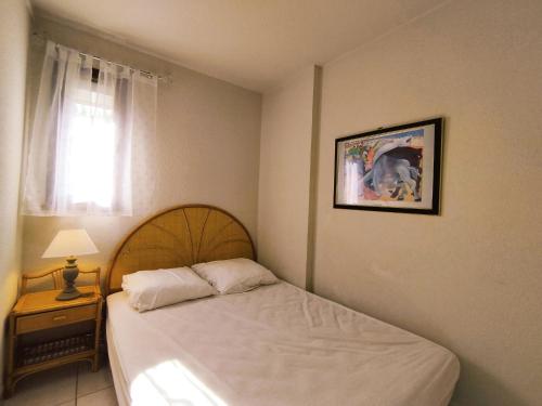 une chambre avec un lit et un tableau au mur dans l'établissement T2 cosy à Narbonne-Plage - 4 pers, proche plage, parking privatif, calme - Découverte et détente ! - FR-1-795-8, à Narbonne