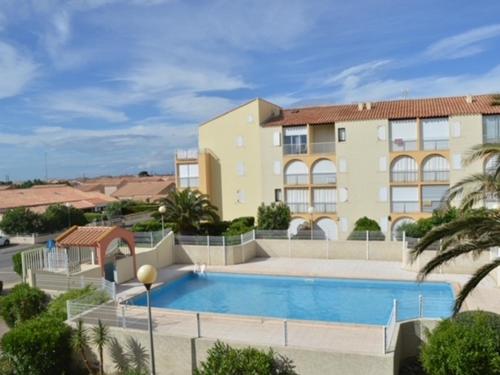 un immeuble avec une piscine devant un immeuble dans l'établissement T3 Mezzanine avec Piscine à 200m de la Plage, Parking Inclus - 6 Pers - FR-1-795-2, à Narbonne