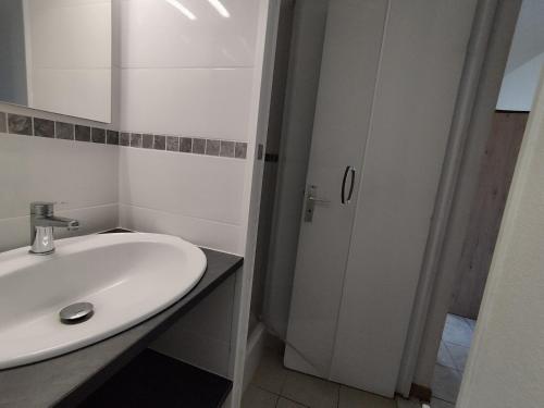une salle de bain blanche avec un lavabo et un miroir dans l'établissement Confortable T2 à Narbonne Plage - 28m2, Proche Mer, 4 Pers, Tout Équipé - FR-1-795-9, à Narbonne