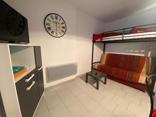 une chambre avec un lit et une horloge au mur dans l'établissement T2 à Narbonne-Plage - Parking & Proche Plage - 5 Pers - FR-1-795-5, à Vert-le-Grand