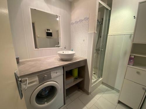 une salle de bain avec une machine à laver et un lavabo dans l'établissement T2 à Narbonne-Plage - Parking & Proche Plage - 5 Pers - FR-1-795-5, à Vert-le-Grand