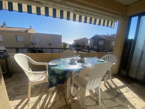 une table et des chaises sur un balcon avec vue dans l'établissement Spacieux T3 climatisé proche plage, balcon, parking privatif - FR-1-795-19, à Narbonne