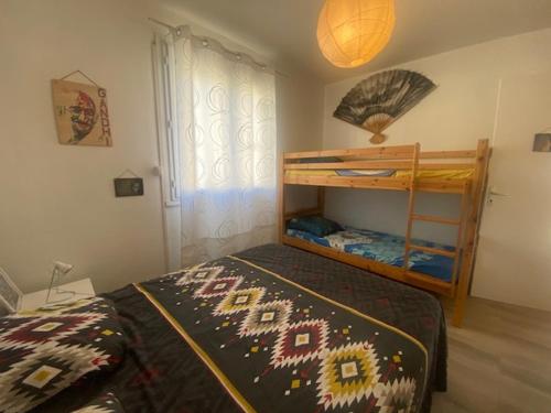 une chambre avec deux lits superposés dans une pièce dans l'établissement Spacieux T3 climatisé proche plage, balcon, parking privatif - FR-1-795-19, à Narbonne