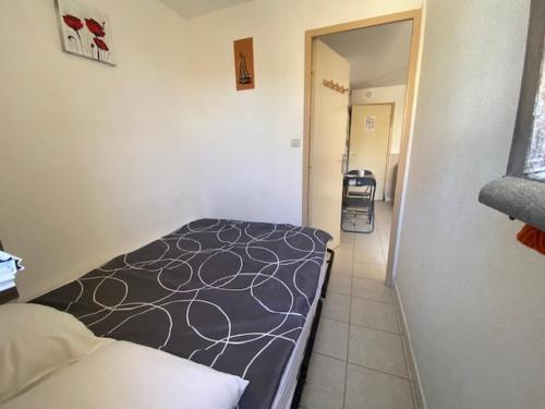 - une petite chambre avec un lit et un couloir dans l'établissement Coquet T2 à Narbonne Plage - Cour arborée, Parking, Proche plage et commerces, 4 pers. - FR-1-795-14, à Narbonne