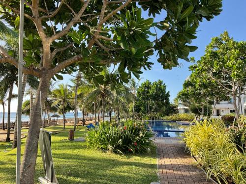 a resort with a swimming pool and palm trees at Beach Bliss in Trincomalee