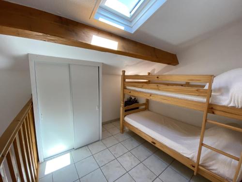 - une chambre avec des lits superposés et une lucarne dans l'établissement Charmante Villa T2 Mezzanine avec Piscine et Parking, à 15 min de la Plage - 5 Pers. - FR-1-795-35, à Fleury
