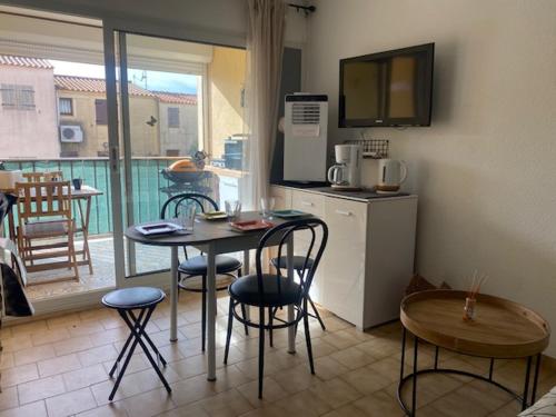 une petite cuisine avec une table et des chaises dans une pièce dans l'établissement Saint-Pierre-La-Mer : Appart T2 avec Piscine, Parking, Clim, Terrasse - 4 Pers. - FR-1-795-26, à Fleury