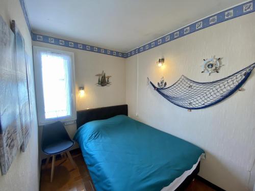 - une chambre avec un lit et un hamac sur le mur dans l'établissement Appartement T3 avec Clim et WIFI à 100m de la Plage - Parking Inclus - 6 Pers. - FR-1-795-34, à Narbonne