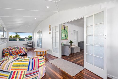 a bedroom with a bed and a living room at Hill Street House in Yeppoon