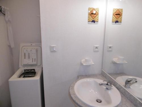 une salle de bain blanche avec un lavabo et un miroir dans l'établissement Villa 7 pers, Narbonne Plage à 400m, 3 ch, terrasses, parking, proche commerces et loisirs - FR-1-795-44, à Narbonne