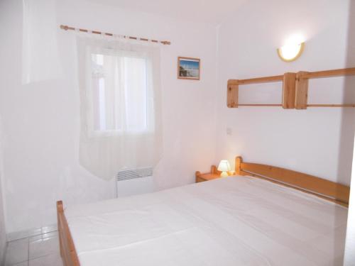 une chambre blanche avec un lit et une fenêtre dans l'établissement Villa 7 pers, Narbonne Plage à 400m, 3 ch, terrasses, parking, proche commerces et loisirs - FR-1-795-44, à Narbonne