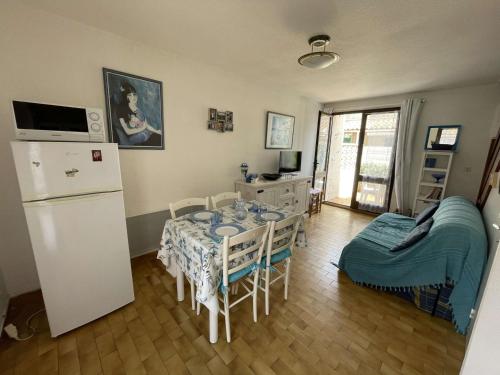 une cuisine avec une table et un réfrigérateur dans l'établissement **Charmante Villa T3 Climatisée à 200m de la Plage avec Parking Privatif - Narbonne-Plage** - FR-1-795-46, à Narbonne