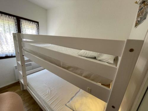 Ce lit superposé blanc se trouve dans un dortoir. dans l'établissement **Charmante Villa T3 Climatisée à 200m de la Plage avec Parking Privatif - Narbonne-Plage** - FR-1-795-46, à Narbonne