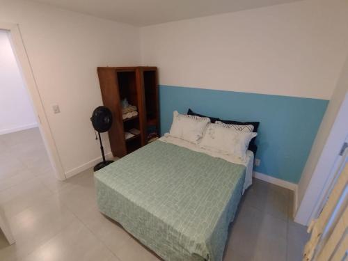 a bedroom with a bed with a blue wall at Apartamento no coração de Petrópolis in Petrópolis