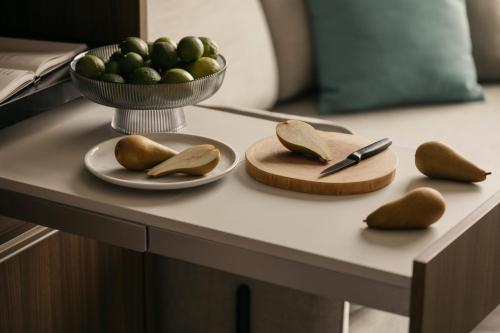 a table with two plates and a bowl of fruit at Quincy House Singapore in Singapore