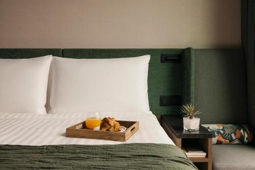 a tray with a bowl of food on a bed at Quincy House Singapore in Singapore