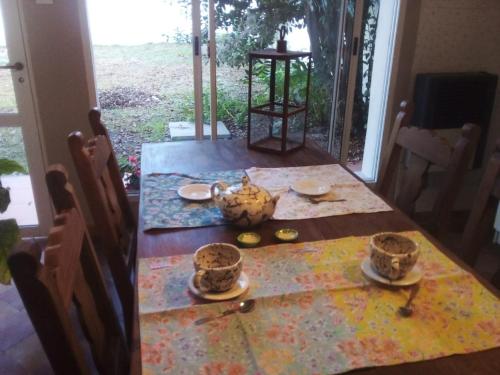 a dining room table with a bowl and cups on it at Casa 1936 in Suipacha
