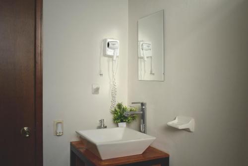 a bathroom with a sink and a phone on the wall at Hermoso departamento a 7 min de los balnearios in Ixmiquilpan