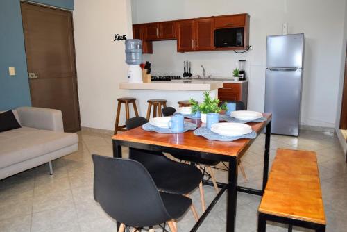 a kitchen with a table with chairs and a refrigerator at Hermoso departamento a 7 min de los balnearios in Ixmiquilpan