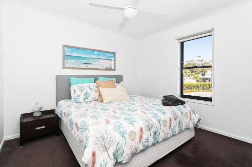 a bedroom with a bed and a window at Mollymook Luxury Beachfront Apartment 10 in Mollymook