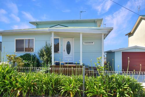a blue house with a fence in front of it at 81 Murrah in Bermagui