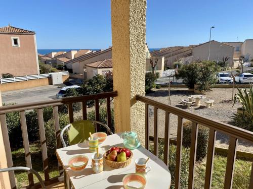 - une table avec une corbeille de fruits sur un balcon dans l'établissement T2 Confortable à Saint-Pierre-La-Mer - 4 Pers, Proche Plage, Tout Équipé, Balcon, Animations à Proximité - FR-1-795-47, à Fleury