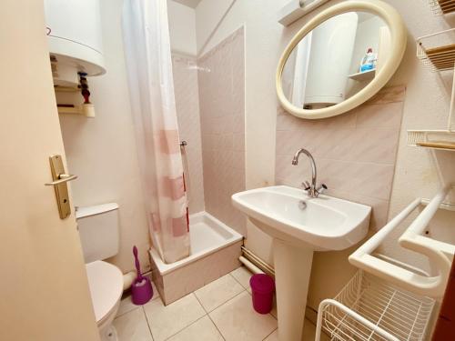 une salle de bain avec un lavabo, des toilettes et un miroir dans l'établissement T2 Confortable à Saint-Pierre-La-Mer - 4 Pers, Proche Plage, Tout Équipé, Balcon, Animations à Proximité - FR-1-795-47, à Fleury