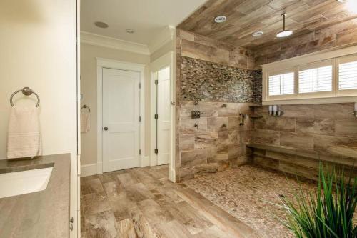 a bathroom with a walk in shower and a stone wall at The Beachfront Estate, 360 Ocean Views, 5700 sqft in Mattapoisett