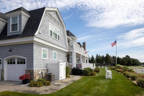 a house with an american flag in the yard at The Beachfront Estate, 360 Ocean Views, 5700 sqft in Mattapoisett