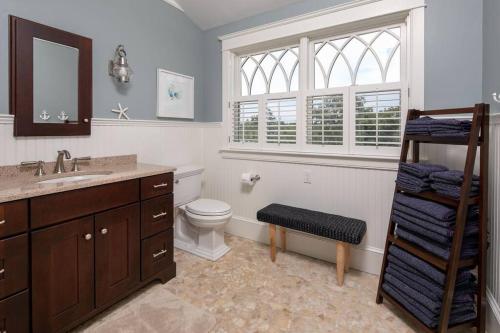 a bathroom with a toilet and a sink and a window at The Beachfront Estate, 360 Ocean Views, 5700 sqft in Mattapoisett