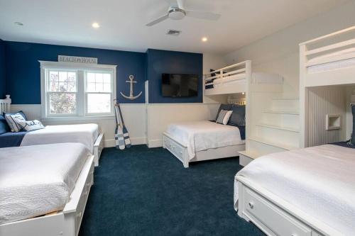 a bedroom with two beds and a tv in it at The Beachfront Estate, 360 Ocean Views, 5700 sqft in Mattapoisett