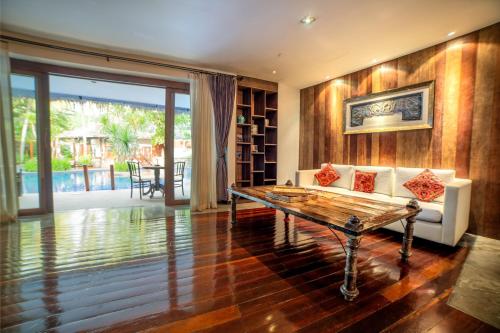 a living room with a table and a couch at Villa Samadhi by Samadhi Age 12 and Above Only in Kuala Lumpur