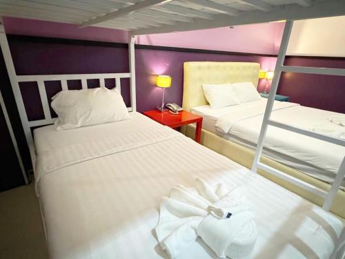 two beds in a room with purple walls at Donmueang Airport Modern bangkok in Ban Ko