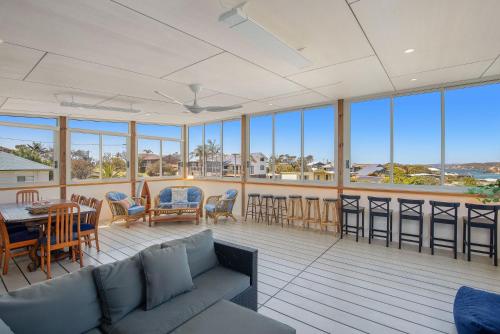 a living room with a couch and a table and chairs at 7 Murrah in Bermagui