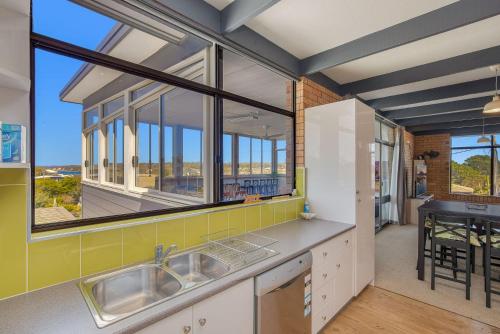 a kitchen with a sink and a large window at 7 Murrah in Bermagui