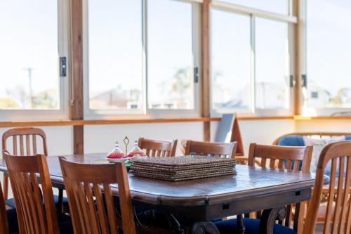 a wooden table with chairs and a table with a box on it at 7 Murrah in Bermagui