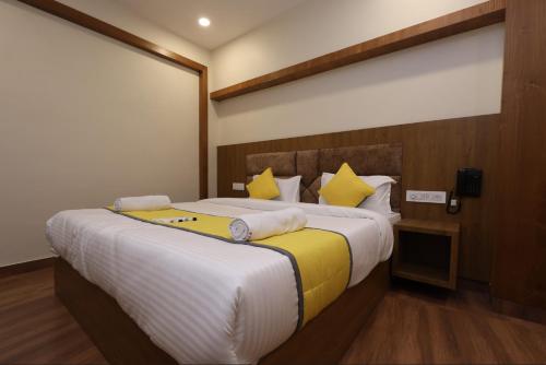 a bedroom with a large bed with yellow pillows at Hotel president park Coimbatore in Coimbatore