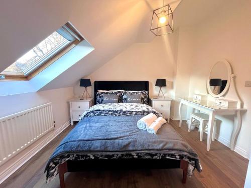 a bedroom with a bed and a desk and a window at Beautiful 3 bedroom home in the heart of Alnwick in Alnwick