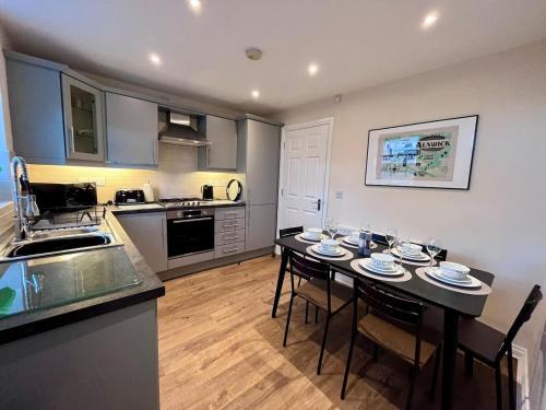 a kitchen with a table and chairs in a room at Beautiful 3 bedroom home in the heart of Alnwick in Alnwick