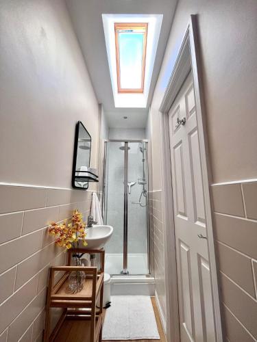 a bathroom with a sink and a shower with a skylight at Beautiful 3 bedroom home in the heart of Alnwick in Alnwick