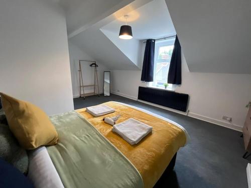 a bedroom with a large bed with two towels on it at Spacious 3 Bedroom House in Pallion