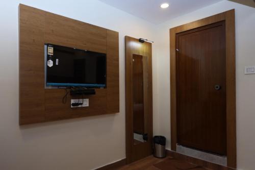 a room with a flat screen tv on a wall at Hotel president park Coimbatore in Coimbatore