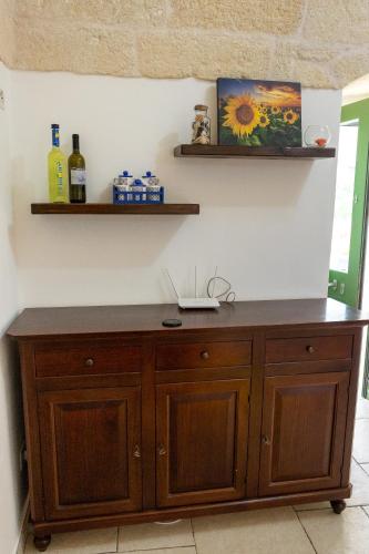 a wooden cabinet against a wall with two shelves at trullo madonna della grotta in Ceglie Messapica