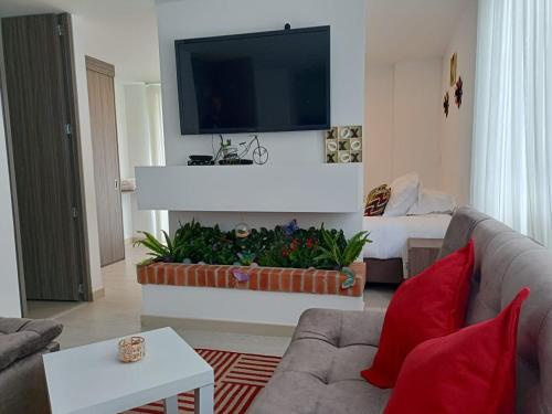 a living room with a couch and a flat screen tv at Arama Apartamento Boutique in Paipa