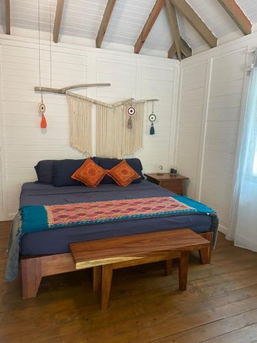 a bedroom with a bed with a bench in it at Sol y Arena Xcalak in Xcalak