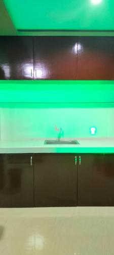a kitchen counter with a sink and green lighting at Pacifico's Hostel in Barili