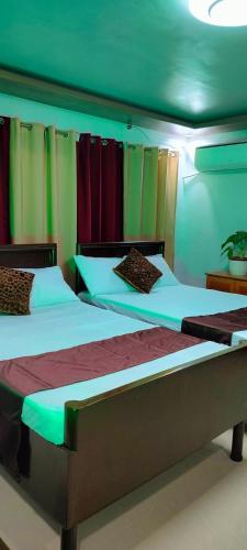 two beds in a room with colorful curtains at Pacifico's Hostel in Barili